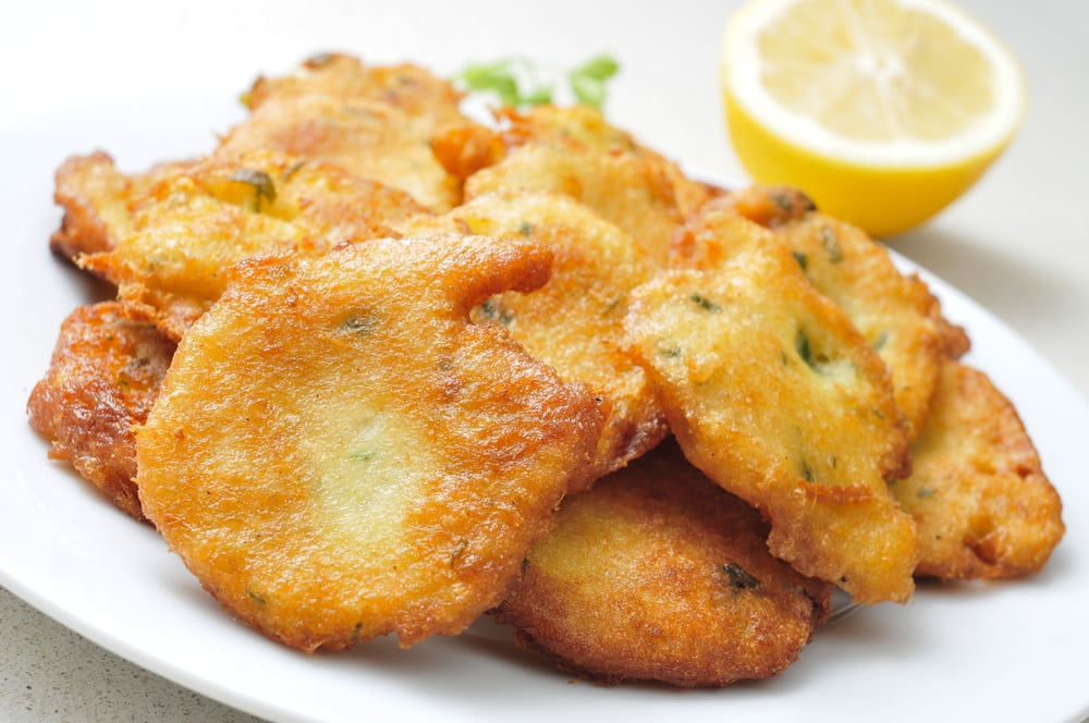 Things to Do In Puerto Rico.  closeup of a plate with a pile of appetizing tortas de bacalao, spanish cod cakes, on a white surface