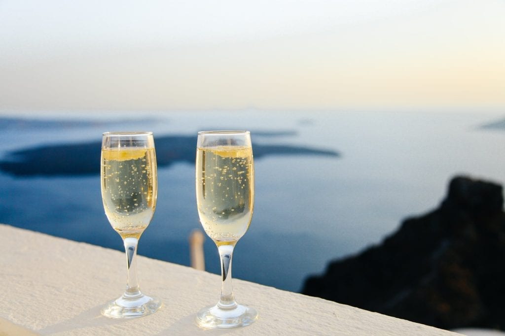 Start a Travel Blog.
two glasses of champagne overlooking a body of water